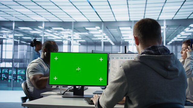 Engineer in server hub using green screen PC to repair equipment storing datasets. Professional using mockup computer to do debugging on rigs doing computational operations, camera B