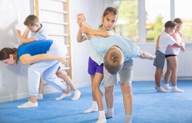 Obraz premium In training hall, children are working on arm twists, learning to control and subdue opponents.
