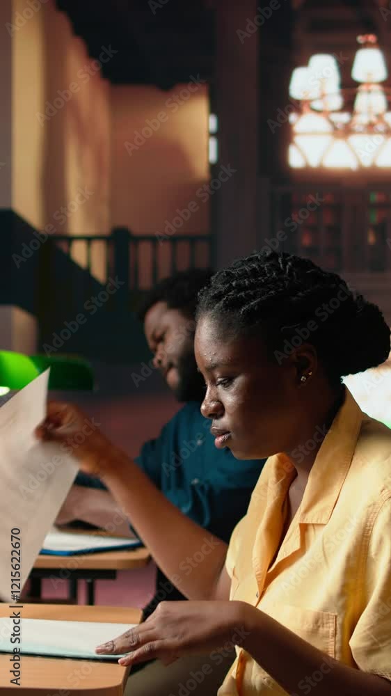 Poster vertical video college student underlining relevant phrases from the class notes using a highlighter