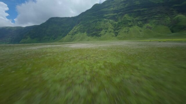 fpv drone flying on the landscape with green grass and lake