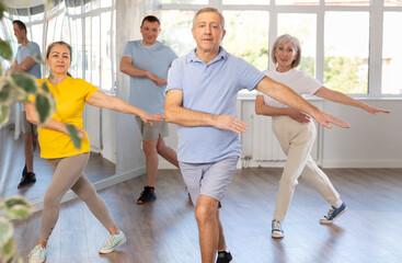 Enthusiastic elderly man attending group choreography class, learning modern dynamic dances....