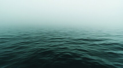 Obraz premium Endless fog meets the soft ripples of an expansive sea, blurring the line between water and sky in a dreamlike panorama.