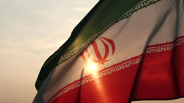 Close up Iran flag waving in the wind against sunset, beautiful cloud sky, outdoor background. Concept of Iran national flag, Iranian, Islamic Republic of Iran, Emblem, Persian, Iranian, War, Freedom
