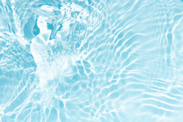 Blue water with ripples on the surface. Defocus blurred transparent blue colored clear calm water surface texture with splashes and bubbles. Water waves with shining pattern texture background.