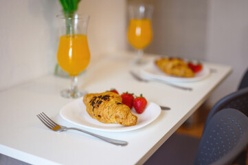Delicious Croissants with Fresh Strawberries and Orange Juice Breakfast Setup – Perfect Morning Dining Presentation