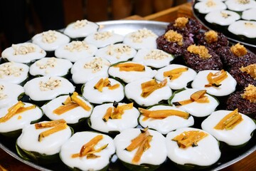 
Khanom Tako at Khlong Lat Mayom, a floating market in Taling Chan, Bangkok, Thailand: a Thai dessert made from glutinous rice flour and coconut cream, served in a pandan leaf or banana leaf casing