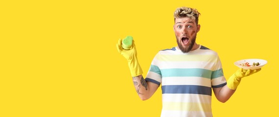 Shocked young man with sponge and dirty plate on yellow background with space for text
