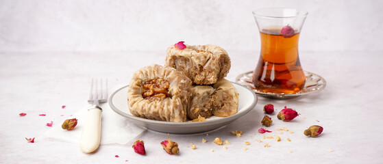 Plate of tasty baklava on light background