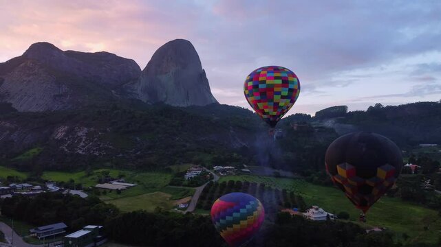 Colorful hot air balloons flying over Pedra Azul, Espirito Santo, Brazil, in an epic sunrise.