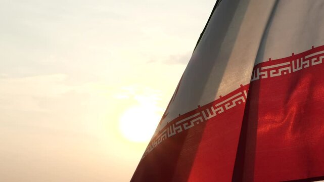 Iran flag waving in the wind against sunset, beautiful cloud sky, outdoor background. Concept of Iran national flag, Iranian, Islamic Republic of Iran, Emblem, Persian, Iranian, War, Freedom