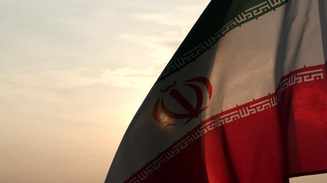 Iran flag waving in the wind against sunset, beautiful cloud sky, outdoor background. Concept of Iran national flag, Iranian, Islamic Republic of Iran, Emblem, Persian, Iranian, War, Freedom