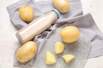 Bottle of tasty potato milk on light background