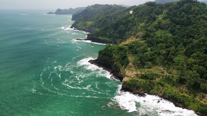 Aerial drone view of coastline with hills and trees, as well as view of coral cliffs and sea with...