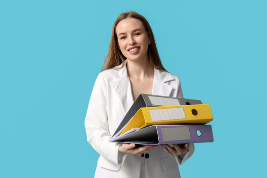 Young businesswoman with document folders on blue background