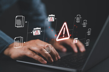 Warning alert icon with a hacked document system.Man typing on a keyboard with a red cybersecurity...