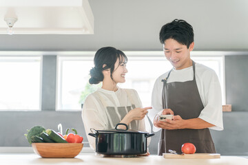 キッチンで料理・家事をする若いアジア人夫婦・カップル（自炊・共働き・ディンクス・趣味）
