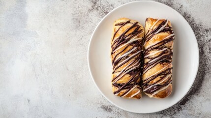 Chocolate drizzled pastry on a white plate with a textured background and Copy Space for text placement