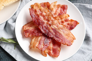 Dish with tasty fried bacon on napkin. Closeup