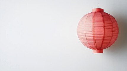 Fototapeta premium Red paper lantern hanging on white wall with ample Copy Space for text placement