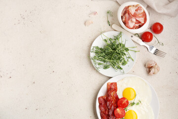 Plate with fried bacon, eggs, vegetables and microgreens on white background. Top view