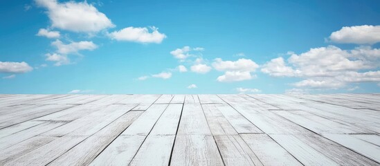 White puzzle pieces on a wooden surface under a clear blue sky with fluffy white clouds and ample empty space for creative text placement.