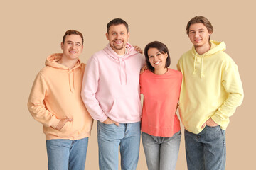 Fototapeta premium Group of young people hugging on beige background