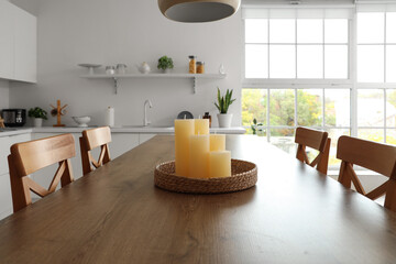 Candles on wooden table in modern kitchen