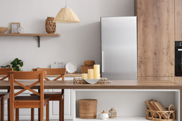 Interior of modern kitchen with candles on tray on table