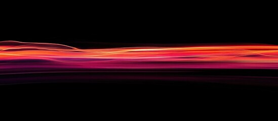 Abstract city light trails with motion blur creating a vibrant background suitable for text or graphic overlay on a dark backdrop.