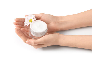 Beautiful female hands with jar of cosmetic cream and chrysanthemum flower on white background