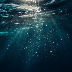 Underwater sunbeams, bubbles, and deep ocean.