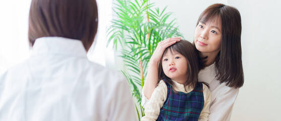 小児科で診察を受ける女の子とお母さん