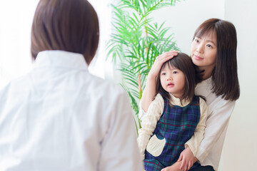 小児科で診察を受ける女の子とお母さん
