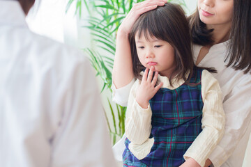 小児科で診察を受ける女の子とお母さん