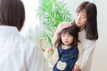 小児科で診察を受ける女の子とお母さん