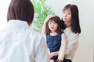 小児科で診察を受ける女の子とお母さん