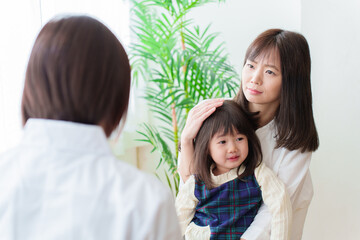 小児科で診察を受ける女の子とお母さん