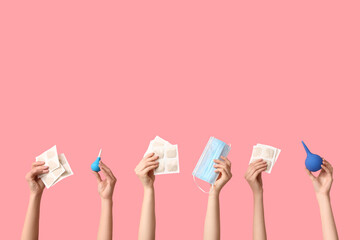 Female hands with mustard plasters, medical mask and enemas on pink background
