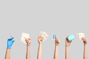 Female hands with mustard plasters, pills, syringe and pill box on grey background