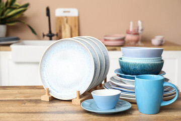 Clean blue dishes on wooden table in kitchen