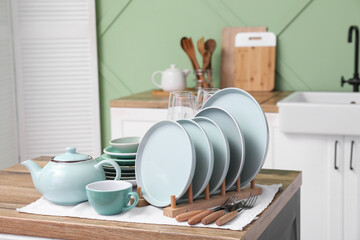 Clean blue dishes on wooden table in kitchen
