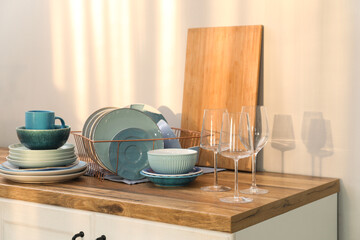 Holder with clean blue dishes on counter in kitchen