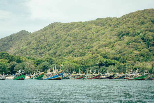 A row of wooden fishing boats on a beautiful beach. Tanjung Papuma, Jember, Indonesia