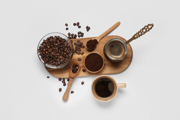 Cezve with cup of coffee, bowl of powder and beans on white background