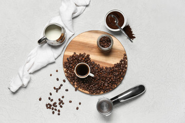 Naklejka premium Cup of coffee with portafilter, powder, beans and jug of milk on white background