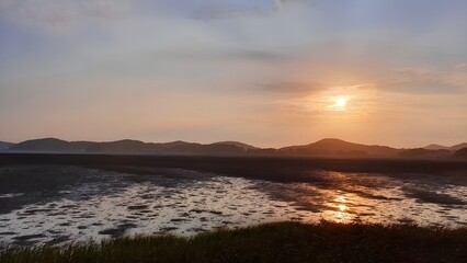 Puesta de sol sobre tierras recuperadas del mar.