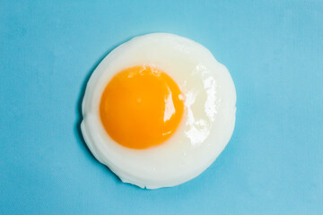 a fried egg isolated on a blue background