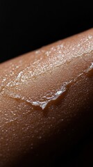 Fototapeta premium Close-up of glistening skin with a wave of lotion applied. The image evokes a sense of hydration and freshness.