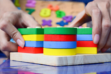 Fototapeta premium Little kids sitting on the floor playing with wooden building blocks together and enjoying family bonding time at home
