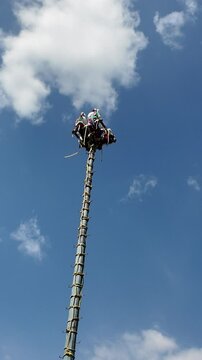 A tall pole with people on top of it